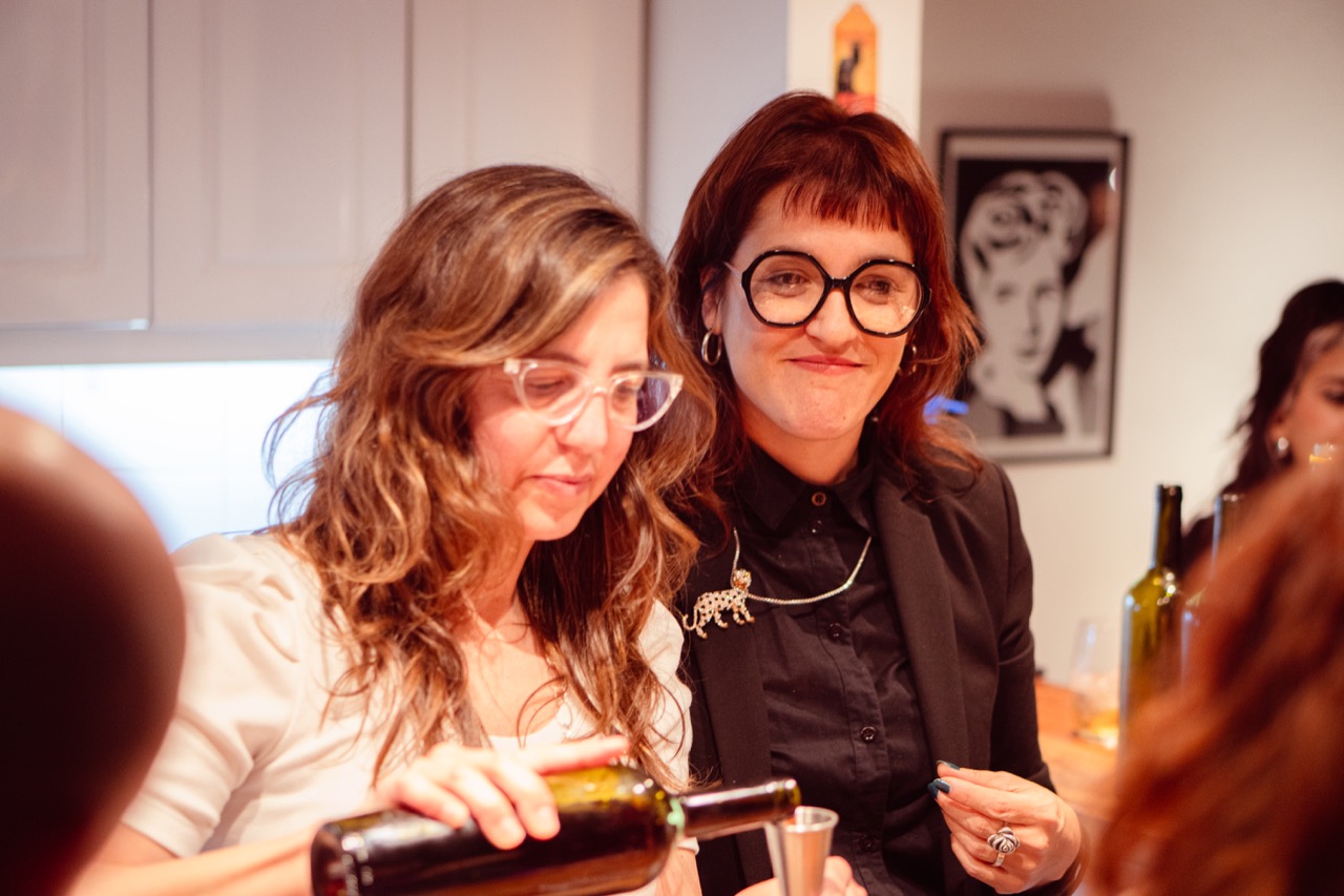 Dos mujeres comparten la preparación del vermú en una mesa